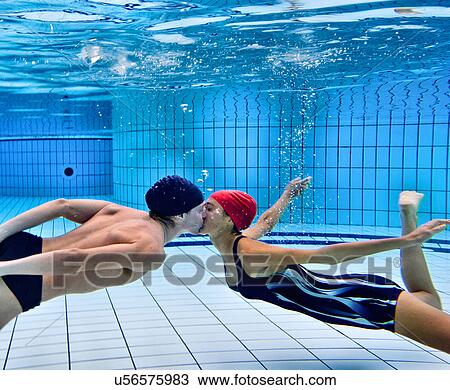 Stock Image - Couple kissing in swimming pool. Fotosearch
