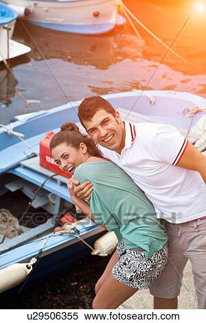Stock Photography - Couple laughing by pier. Fotosearch
