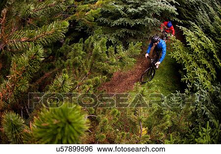 Couple mountain biking on dirt path View Large Photo Image Stock Photograph - Couple mountain biking on dirt path. Fotosearch