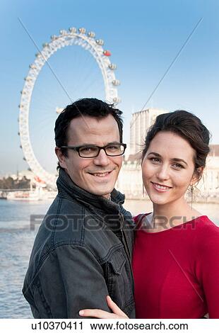 Couple outside London Eye ferris wheel View Large Photo Image Stock Image - Couple outside London Eye ferris wheel. Fotosearch