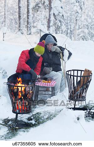 Couple picnicking by fire in snow View Large Photo Image Stock Photography - Couple picnicking by fire in snow. Fotosearch