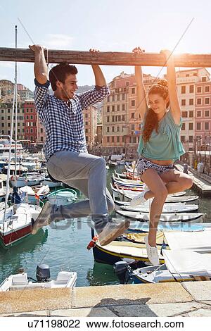 Couple playing on urban pier View Large Photo Image Stock Image - Couple playing on urban pier. Fotosearch