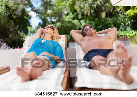 Couple relaxing in lawn chairs View Large Photo Image Stock Photo - Couple relaxing in lawn chairs. Fotosearch