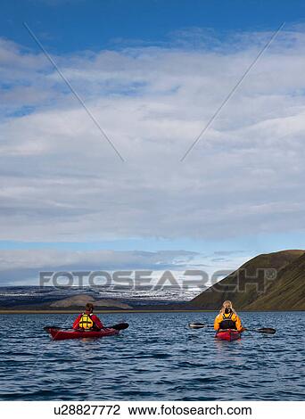 Couple rowing canoes in still lake View Large Photo Image Stock Image - Couple rowing canoes in still lake. Fotosearch