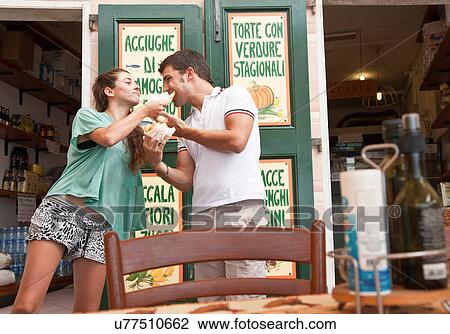 Stock Image - Couple sharing food at cafe. Fotosearch