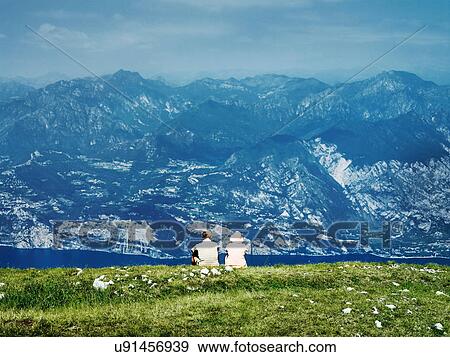 Stock Photo - Couple sitting on rural hillside. Fotosearch