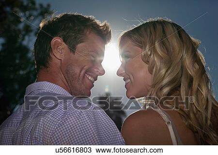 Stock Image - Couple smiling at each other outdoors. Fotosearch