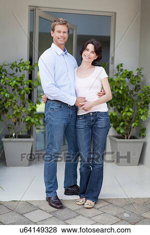 Couple smiling outside front door View Large Photo Image Stock Photo - Couple smiling outside front door. Fotosearch