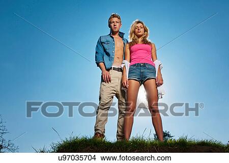 Picture - Couple standing on grassy hill. Fotosearch