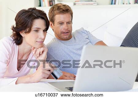 Couple using laptop together View Large Photo Image Stock Photo - Couple using laptop together. Fotosearch