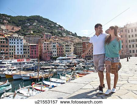 Stock Photo - Couple walking along urban pier. Fotosearch