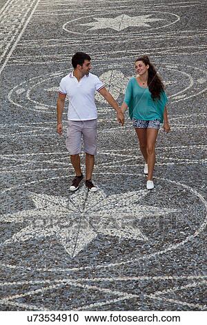 Stock Image - Couple walking on ornate city street. Fotosearch