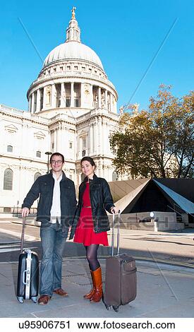 Stock Image - Couple with luggage outside cathedral. Fotosearch