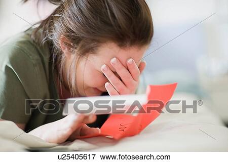 Stock Photo - Crying teenage girl reading letter. Fotosearch