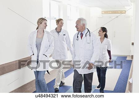 Doctors walking together in hospital View Large Photo Image Stock Image - Doctors walking together in hospital. Fotosearch