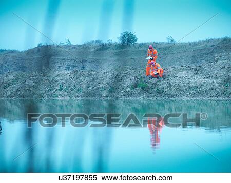Ecologists in reflective clothing inspecting water in quarry site View Large Photo Image Stock Photography - Ecologists in reflective clothing inspecting water in quarry site. Fotosearch