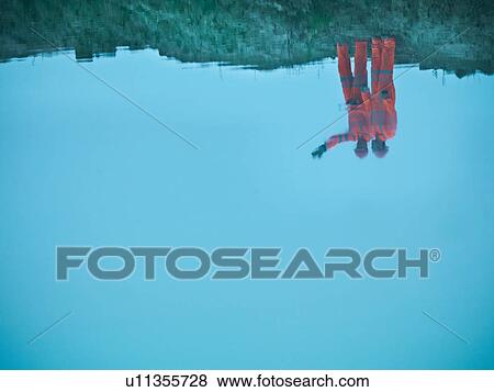 Stock Photo - Ecologists reflected in water on quarry site. Fotosearch