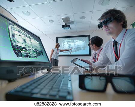 Stock Photo - Engineers and apprentice in meeting room wearing 3D glasses to look at 3D screens. Fotosearch