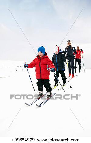 Family cross country skiing in snow View Large Photo Image Stock Photo - Family cross country skiing in snow. Fotosearch