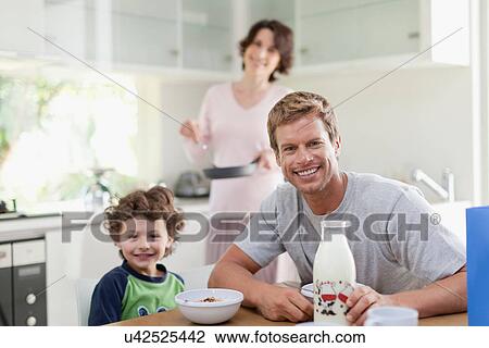 Family eating breakfast in kitchen View Large Photo Image Stock Image - Family eating breakfast in kitchen. Fotosearch
