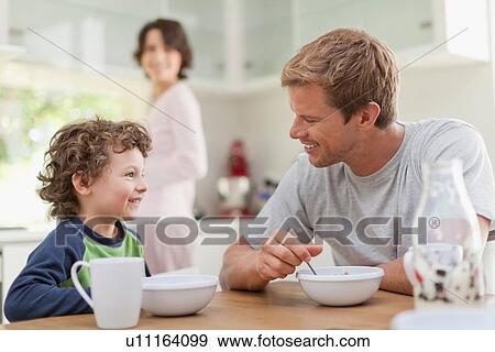 Stock Photo - Family eating breakfast in kitchen. Fotosearch