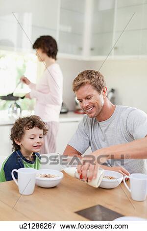 Family eating breakfast in kitchen View Large Photo Image Stock Photo - Family eating breakfast in kitchen. Fotosearch