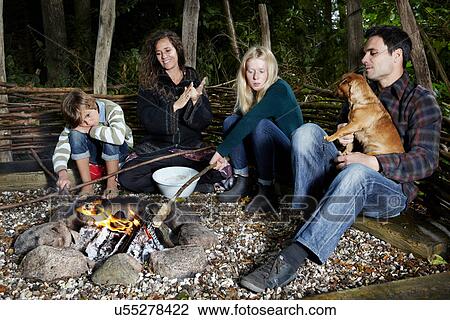 Family relaxing by fire outdoors View Large Photo Image Stock Image - Family relaxing by fire outdoors. Fotosearch