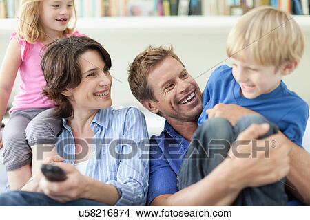 Family relaxing together on couch View Large Photo Image Picture - Family relaxing together on couch. Fotosearch