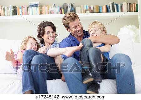 Family relaxing together on couch View Large Photo Image Stock Image - Family relaxing together on couch. Fotosearch
