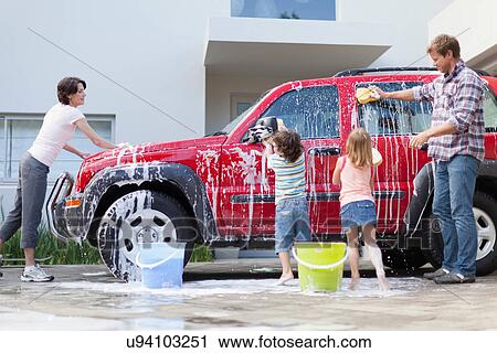 Stock Image - Family washing car together. Fotosearch