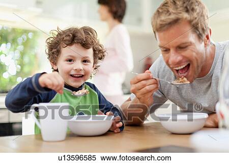 Stock Photography - Father and son eating breakfast. Fotosearch