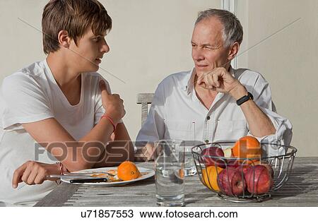 Father and son eating fruit outdoors View Large Photo Image Stock Image - Father and son eating fruit outdoors. Fotosearch