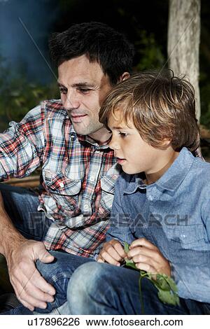 Father and son sitting together outdoors View Large Photo Image Stock Photograph - Father and son sitting together outdoors. Fotosearch
