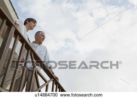 Father and son standing on balcony View Large Photo Image Stock Image - Father and son standing on balcony. Fotosearch
