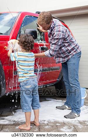 Stock Image - Father and son washing car together. Fotosearch