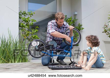 Father helping son fix bicycle View Large Photo Image Picture - Father helping son fix bicycle. Fotosearch