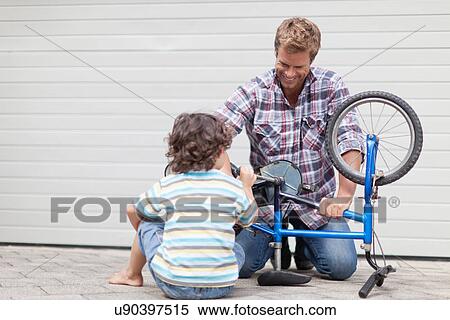 Father helping son fix bicycle View Large Photo Image Stock Photography - Father helping son fix bicycle. Fotosearch