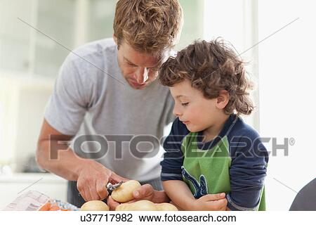 Father helping son peel potatoes View Large Photo Image Stock Image - Father helping son peel potatoes. Fotosearch