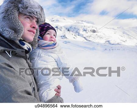 Picture - Father holding baby in snowy landscape. Fotosearch