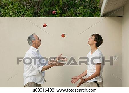 Stock Photo - Father teaching son to juggle outdoors. Fotosearch