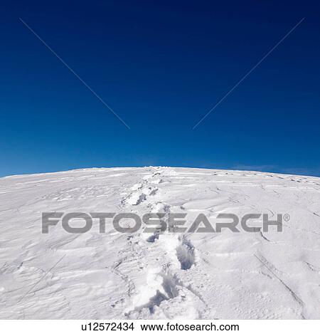 Picture - Footprints on snowy hill. Fotosearch