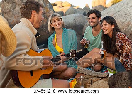 Friends drinking and relaxing on beach View Large Photo Image Stock Photo - Friends drinking and relaxing on beach. Fotosearch