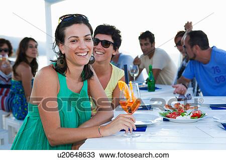 Friends drinking at table outdoors View Large Photo Image Stock Image - Friends drinking at table outdoors. Fotosearch