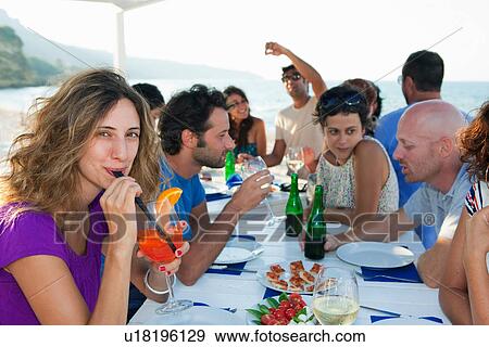 Friends drinking at table outdoors View Large Photo Image Stock Photo - Friends drinking at table outdoors. Fotosearch