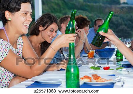Friends drinking at table outdoors View Large Photo Image Stock Photo - Friends drinking at table outdoors. Fotosearch