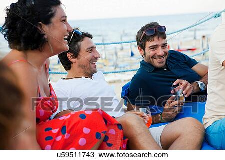 Stock Image - Friends drinking together outdoors. Fotosearch