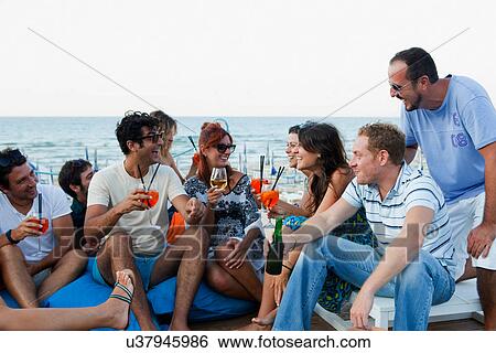 Stock Photograph - Friends drinking together outdoors. Fotosearch