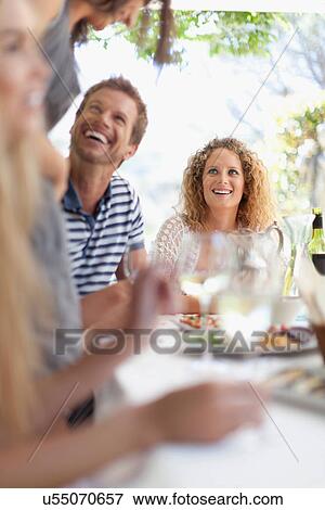 Friends eating at table outdoors View Large Photo Image Stock Photo - Friends eating at table outdoors. Fotosearch