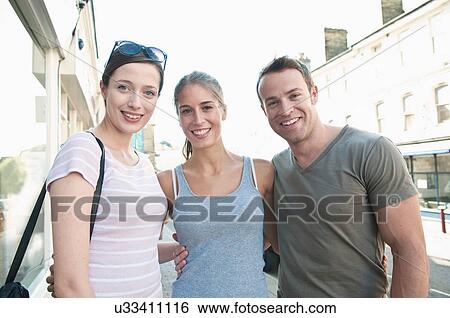 Stock Photograph - Friends hugging on city street. Fotosearch