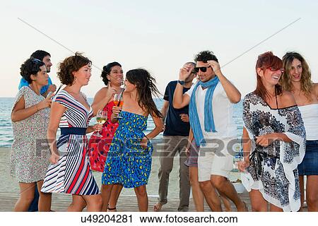 Friends laughing together on beach View Large Photo Image Stock Image - Friends laughing together on beach. Fotosearch